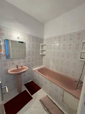 a bathroom with a pink tub and a sink at Appartement Dadi in Rabat