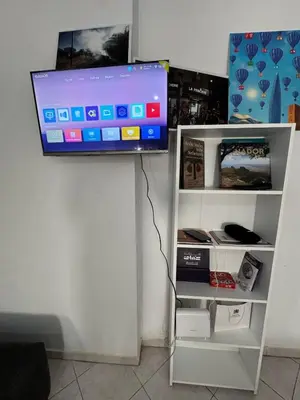 a flat screen tv on top of a white shelf at Appartement Dadi in Rabat