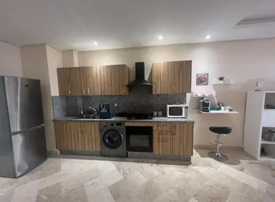 a kitchen with a stove and a refrigerator and a microwave at Neuf 3min de la plage au parc avec parking in Mohammedia