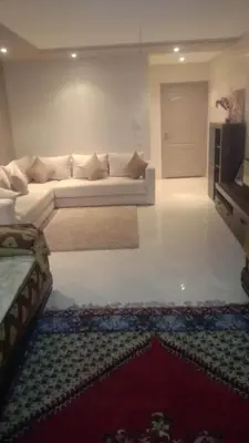 a living room with a white couch and a rug at Nid Douillet Bouznika A7mn de la playa in Bouznika