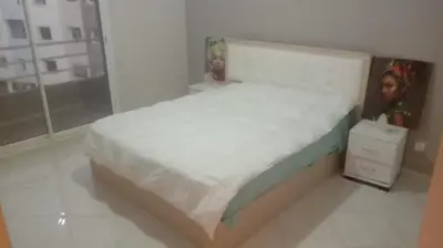 a bedroom with a white bed with two dolls on it at Nid Douillet Bouznika A7mn de la playa in Bouznika