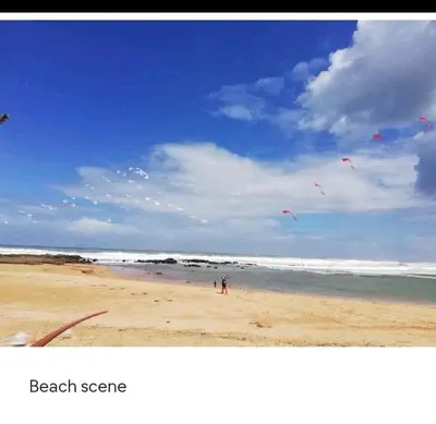 two people are flying kites on a beach at Nid Douillet Bouznika A7mn de la playa in Bouznika