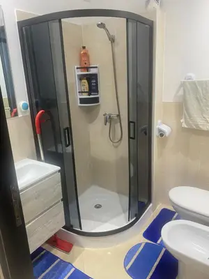 a bathroom with a shower with a sink and a toilet at Appartement balnéaire équipé in Sidi Rahal
