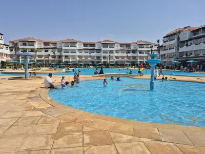 a group of people playing in a swimming pool at Appartement balnéaire équipé in Sidi Rahal