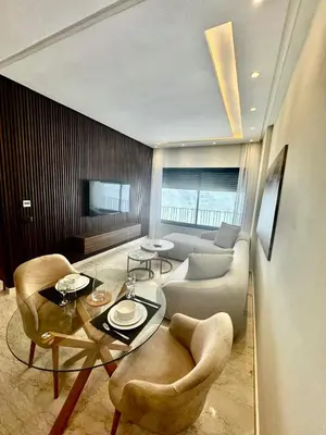 a living room with a table and chairs and a couch at studio tout confort, près de la corniche Casablanca in Casablanca