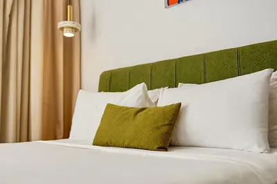 a bed with white pillows and a green headboard at Les Princesse superbe Studio neuf moderne in Casablanca