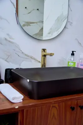 a black sink on a wooden vanity with a mirror at Les Princesse superbe Studio neuf moderne in Casablanca