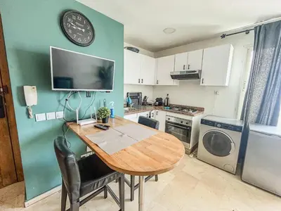 a kitchen with a table and a clock on the wall at Central and Practical Studio - Boulevard d'Anfa in Casablanca