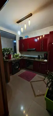 a kitchen with red cabinets and a washer and dryer at Luxury apartment in a prime location and quiet in Casablanca