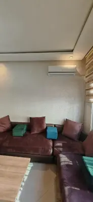 a brown couch with pillows in a room at Luxury apartment in a prime location and quiet in Casablanca