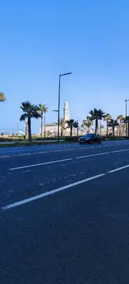 a car parked on the side of a road with palm trees at Luxury apartment in a prime location and quiet in Casablanca