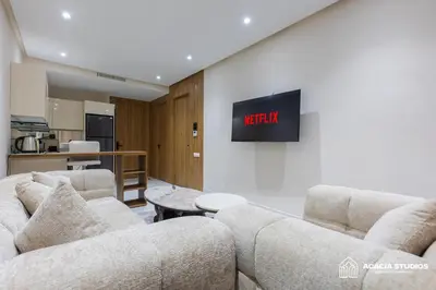 a living room with two couches and a tv on a wall at Acacia Studios in Casablanca