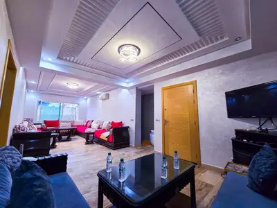 a living room with couches and a flat screen tv at Spacious & chic - 3 min from Casa City Finance 
