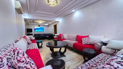 a living room with a red couch and a table at Spacious & chic - 3 min from Casa City Finance 