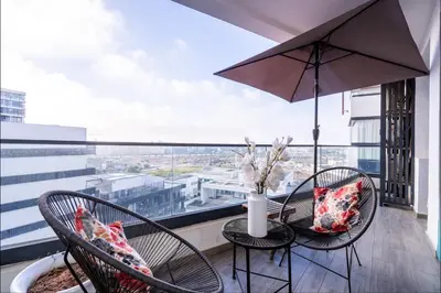 a balcony with two chairs and a table with an umbrella at Appartement de haut standing au centre ville in Casablanca