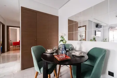 a dining room with a black table and green chairs at Appartement de haut standing au centre ville in Casablanca