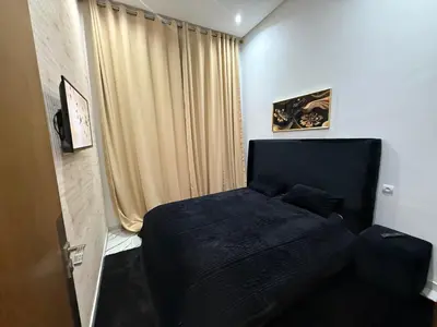 a small bedroom with a bed and a curtain at Studio cosy connecté in Casablanca