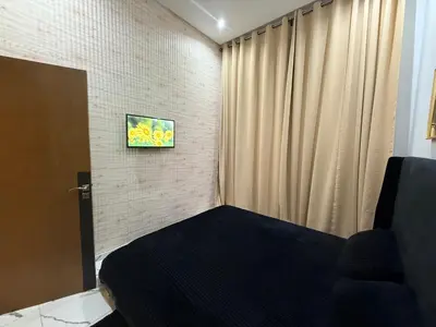 a small bedroom with a bed and a curtain at Studio cosy connecté in Casablanca
