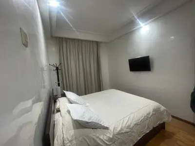 a bedroom with a bed and a television on the wall at Avenue cimetière bourgogne Casablanca in Casablanca
