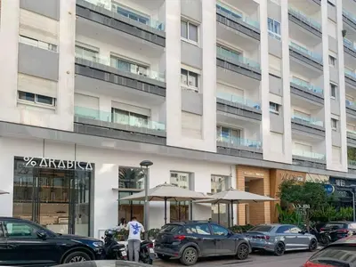 a large building with cars parked in front of it at Luxueux studio spacieux à racine Casablanca à une minute de twin center in Casablanca