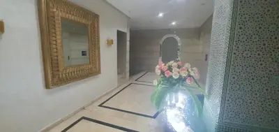 a hallway with a mirror and a vase with flowers at Residence kheir in Casablanca