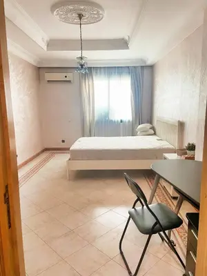 a bedroom with a bed and a table and a chair at Residence kheir in Casablanca
