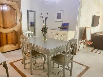 a dining room table with chairs and a vase with flowers at Residence kheir in Casablanca