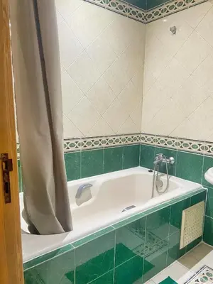 a bathroom with a bath tub with green tile at Residence kheir in Casablanca