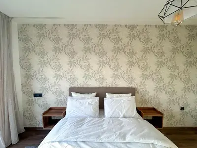 a bedroom with a bed and a wall with wallpaper at Appartement luxueux 2 Chambres avec salle de sport et parking in Casablanca