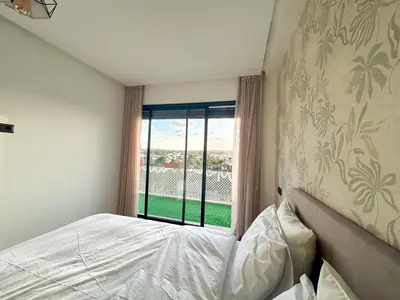 a bedroom with a bed and a window at Appartement luxueux 2 Chambres avec salle de sport et parking in Casablanca