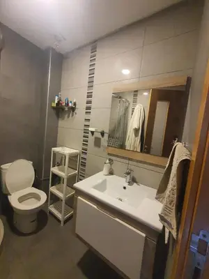 a bathroom with a sink and a toilet and a mirror at apart Blanca beach sur mer in Sidi Rahal