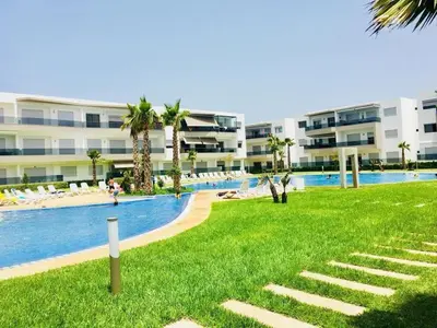 a resort with a pool and a beach and buildings at apart Blanca beach sur mer in Sidi Rahal