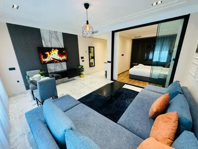 a living room with a blue couch and a bedroom at Les Joyeux Luxury Studios et Suites in Casablanca