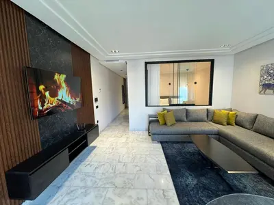 a living room with a couch and a flat screen tv at Les Joyeux Luxury Studios et Suites in Casablanca