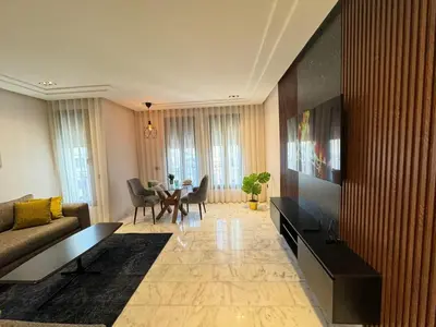 a living room with a couch and a television at Les Joyeux Luxury Studios et Suites in Casablanca