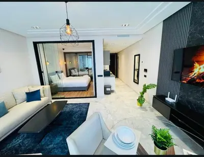 a living room with a couch and a bed and a tv at Les Joyeux Luxury Studios et Suites in Casablanca