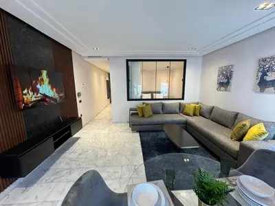 a living room with a couch and a flat screen tv at Les Joyeux Luxury Studios et Suites in Casablanca