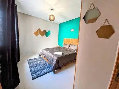 a bedroom with a bed and a green wall at Green Haven Near Airport Stay in Deroua