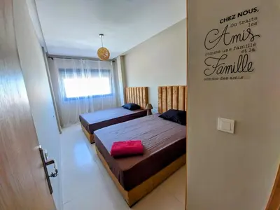 a bedroom with two beds and a door open at Green Haven Near Airport Stay in Deroua