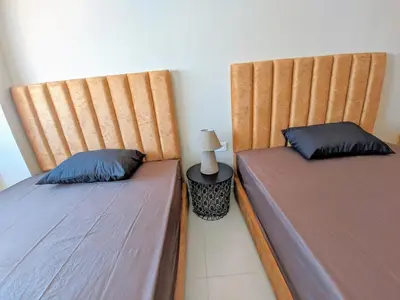 two beds sitting next to each other in a room at Green Haven Near Airport Stay in Deroua