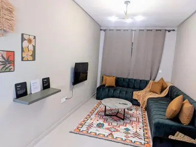 a living room with a couch and a table at Green Haven Near Airport Stay in Deroua