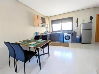 a kitchen with a table and chairs in a room at Green Haven Near Airport Stay in Deroua