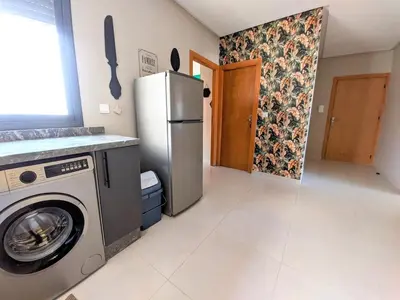a kitchen with a refrigerator and a washing machine at Green Haven Near Airport Stay in Deroua