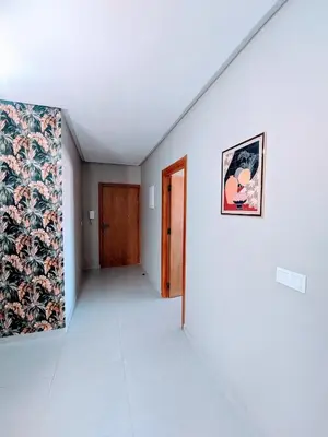 a hallway with a door and a picture on the wall at Green Haven Near Airport Stay in Deroua