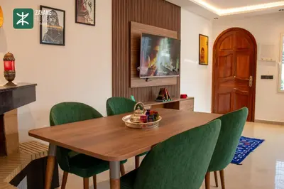 a dining room with a wooden table and green chairs at Beachside Retreat Rabat - Zayane Homes in Temara