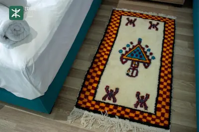 a box with a cross stitch rug on the floor at Beachside Retreat Rabat - Zayane Homes in Temara