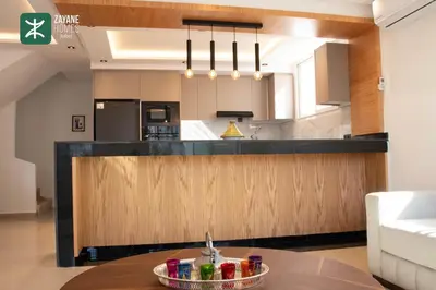 a large kitchen with a counter and a table at Beachside Retreat Rabat - Zayane Homes in Temara
