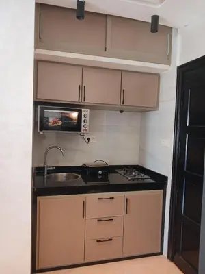 a small kitchen with a sink and a microwave at Appartement Lumineux Front de Mer à CASABLANCA in Casablanca