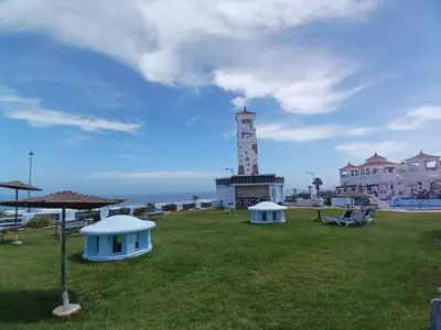 a light house with a clock tower in a field at Appartement Lumineux Front de Mer à CASABLANCA in Casablanca