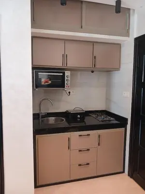 a small kitchen with a sink and a microwave at Appartement Lumineux Front de Mer à CASABLANCA in Casablanca